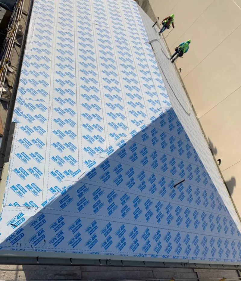 Professional roofers installing underlayment on a metal roof in Rehoboth